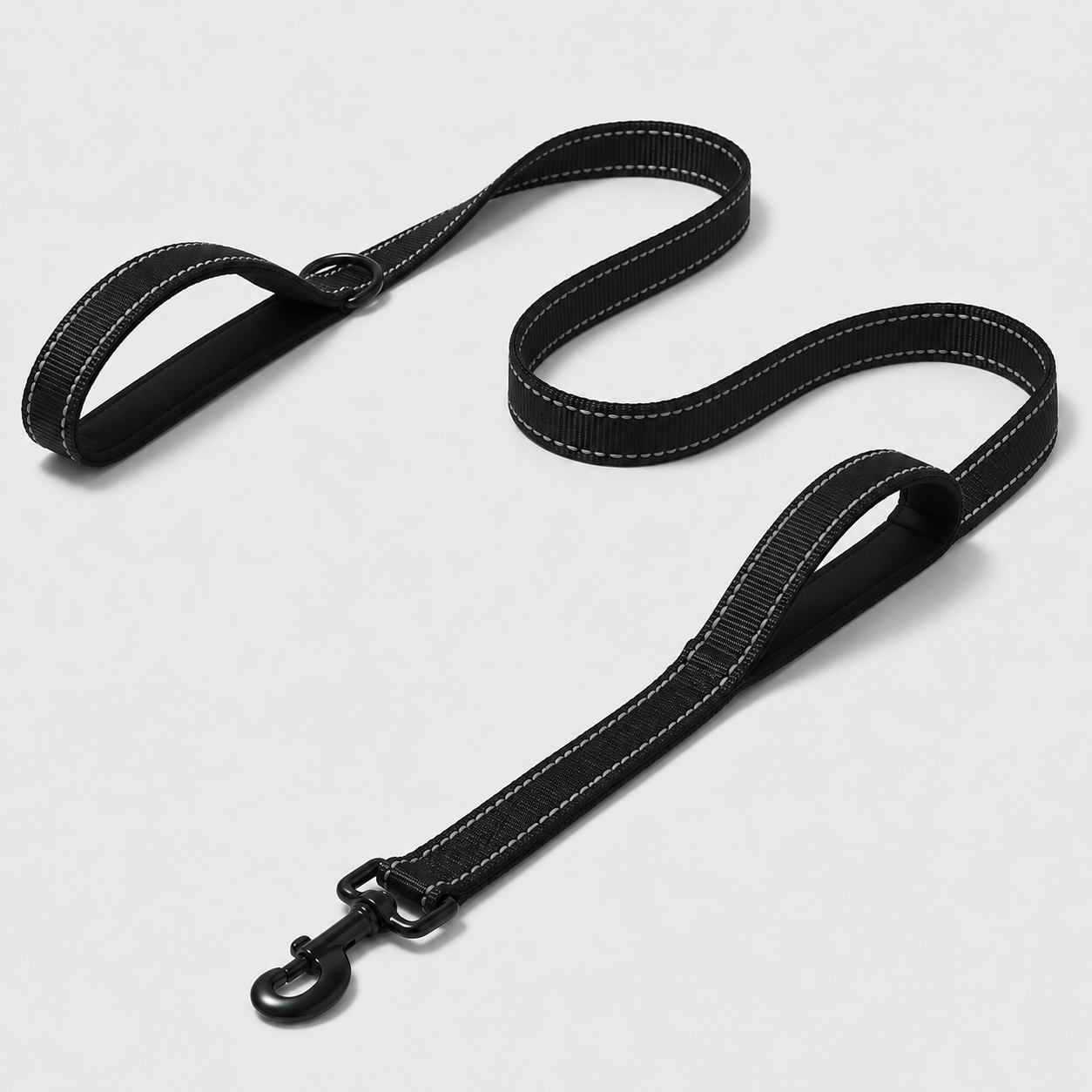 Black dog leash with white stitching on a light grey background