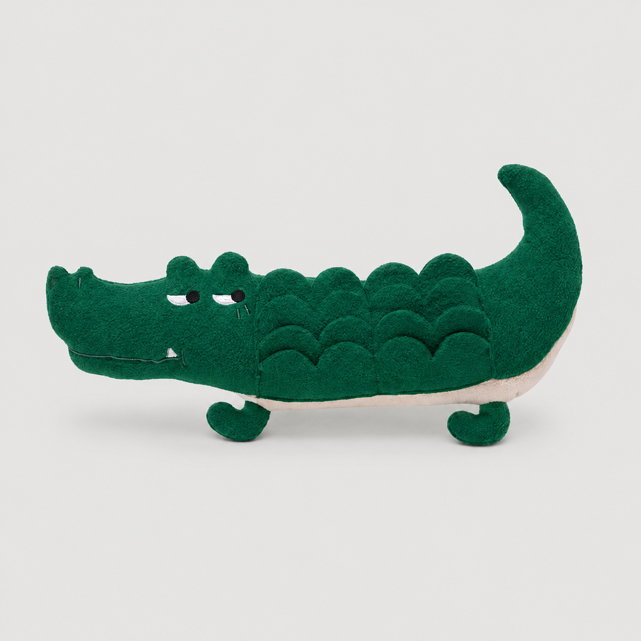 Green crocodile toy on a light grey background