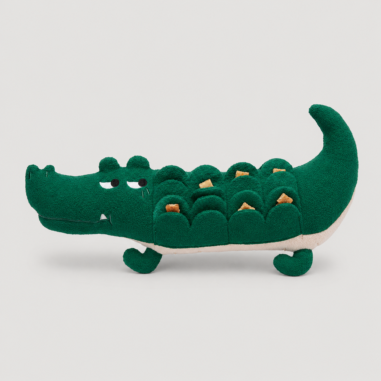 Green plush toy crocodile on a light grey background