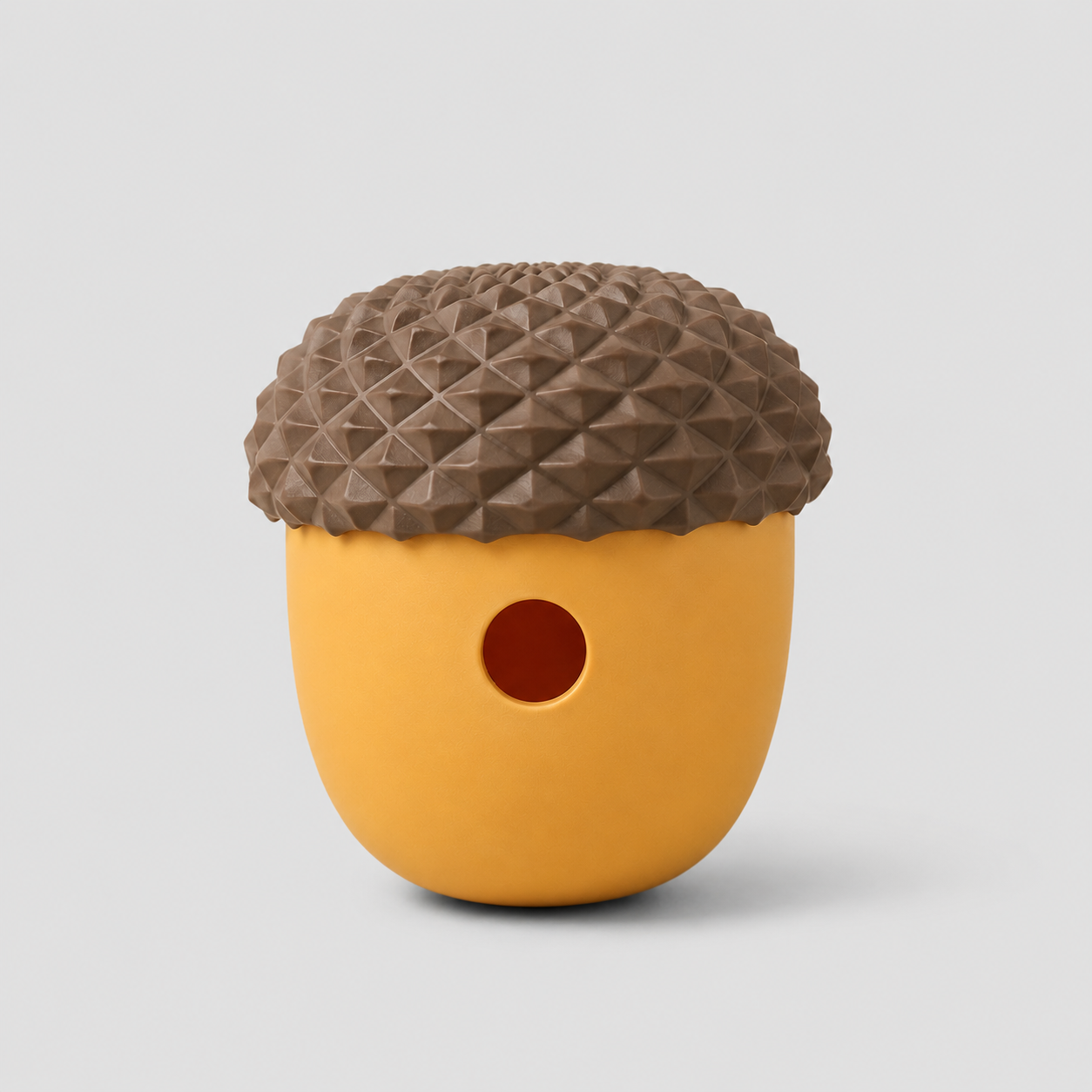 Dog toy shaped like an acorn with a textured brown top and yellow body on a light grey background