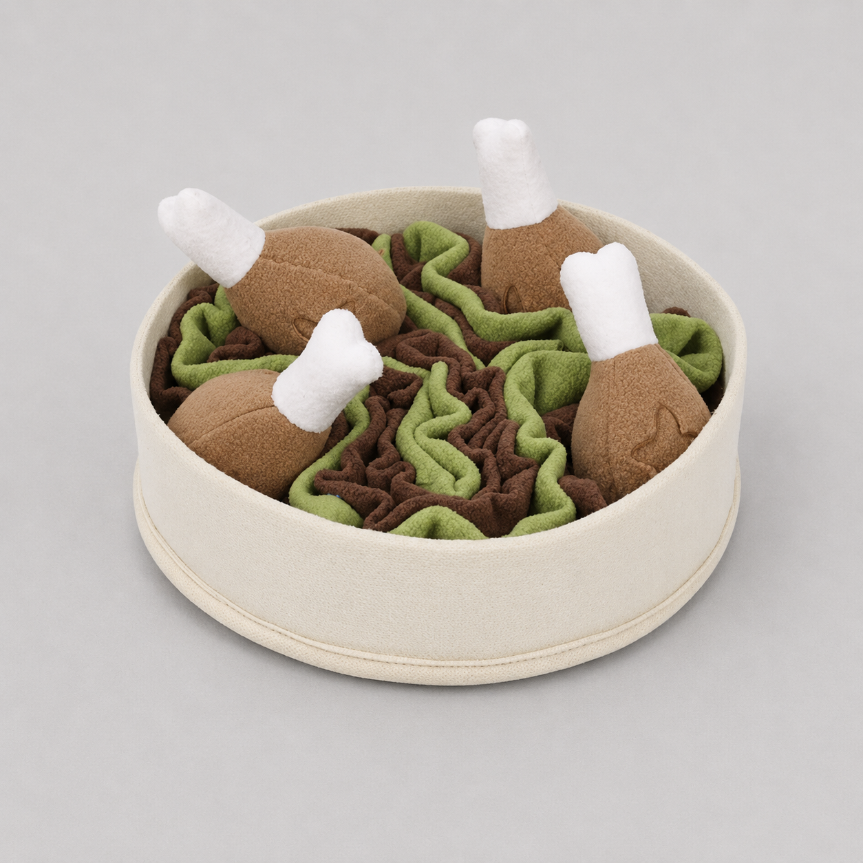 Pet toy set with brown chicken drumsticks and green and brown fabric pieces a light grey background
