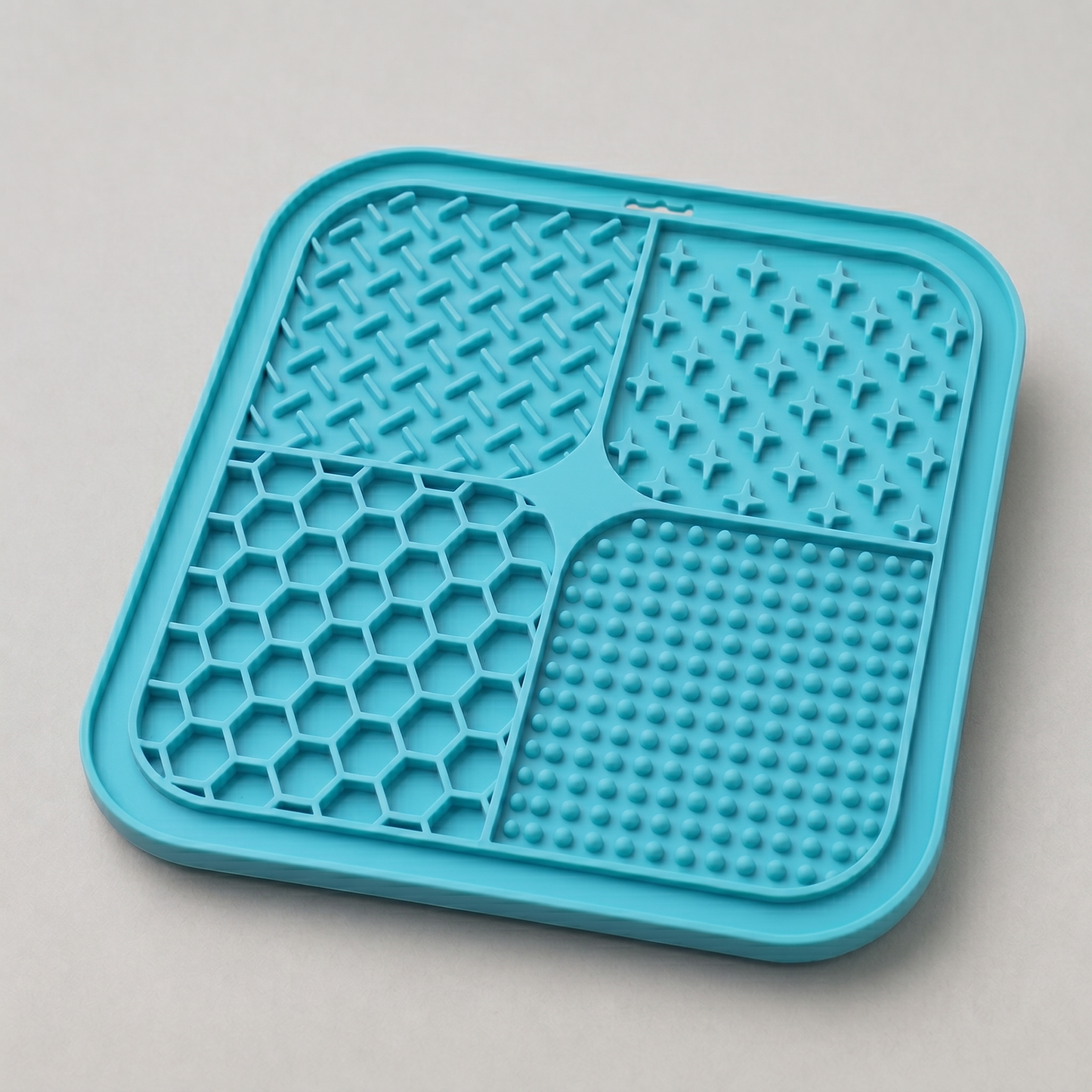 Cyan dog lick silicone mat with textured surface on a light gray background