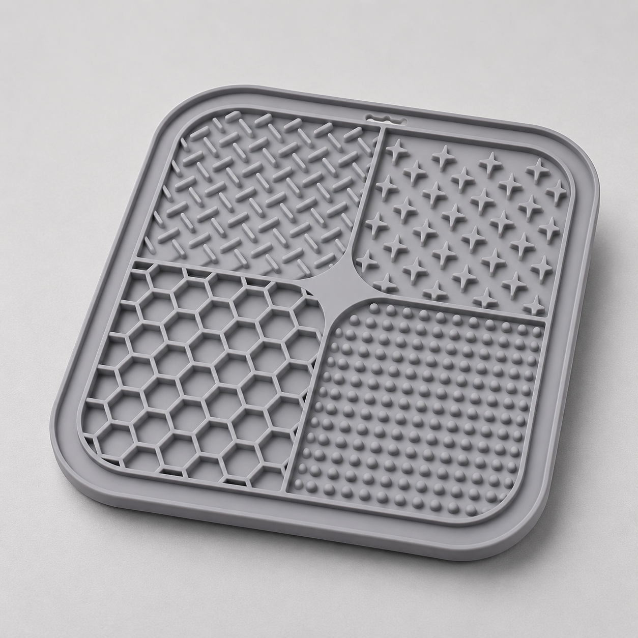 Grey dog lick silicone mat with textured surface on a light gray background
