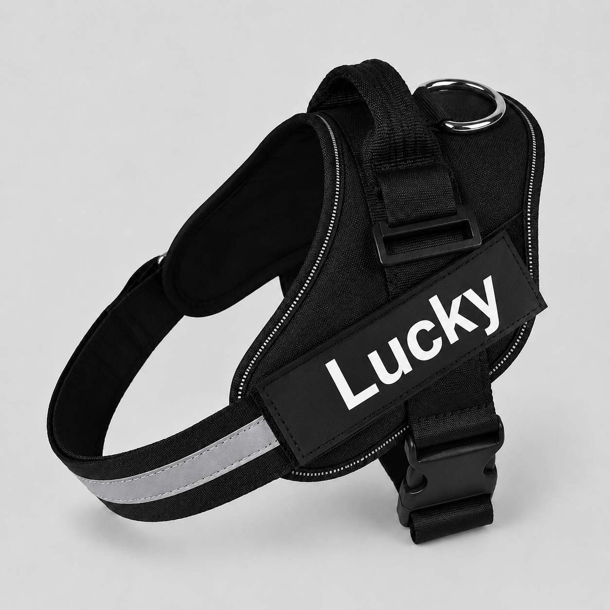 Black dog harness with 'Lucky' label on a light gray background