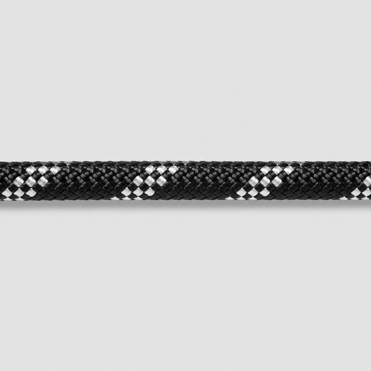Close-up of a black and white braided rope on a light gray background