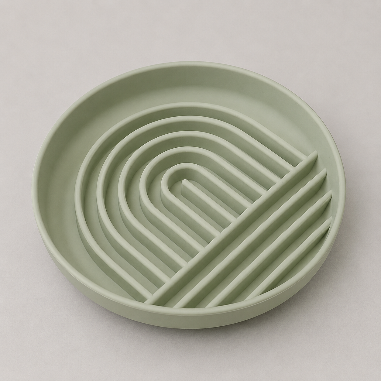 Sage green dog slow feeder bowl with a wavy design on a light gray background