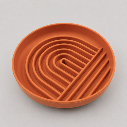 Terracotta-colored silicone dog slow feeder bowl with wavy design on a light gray background