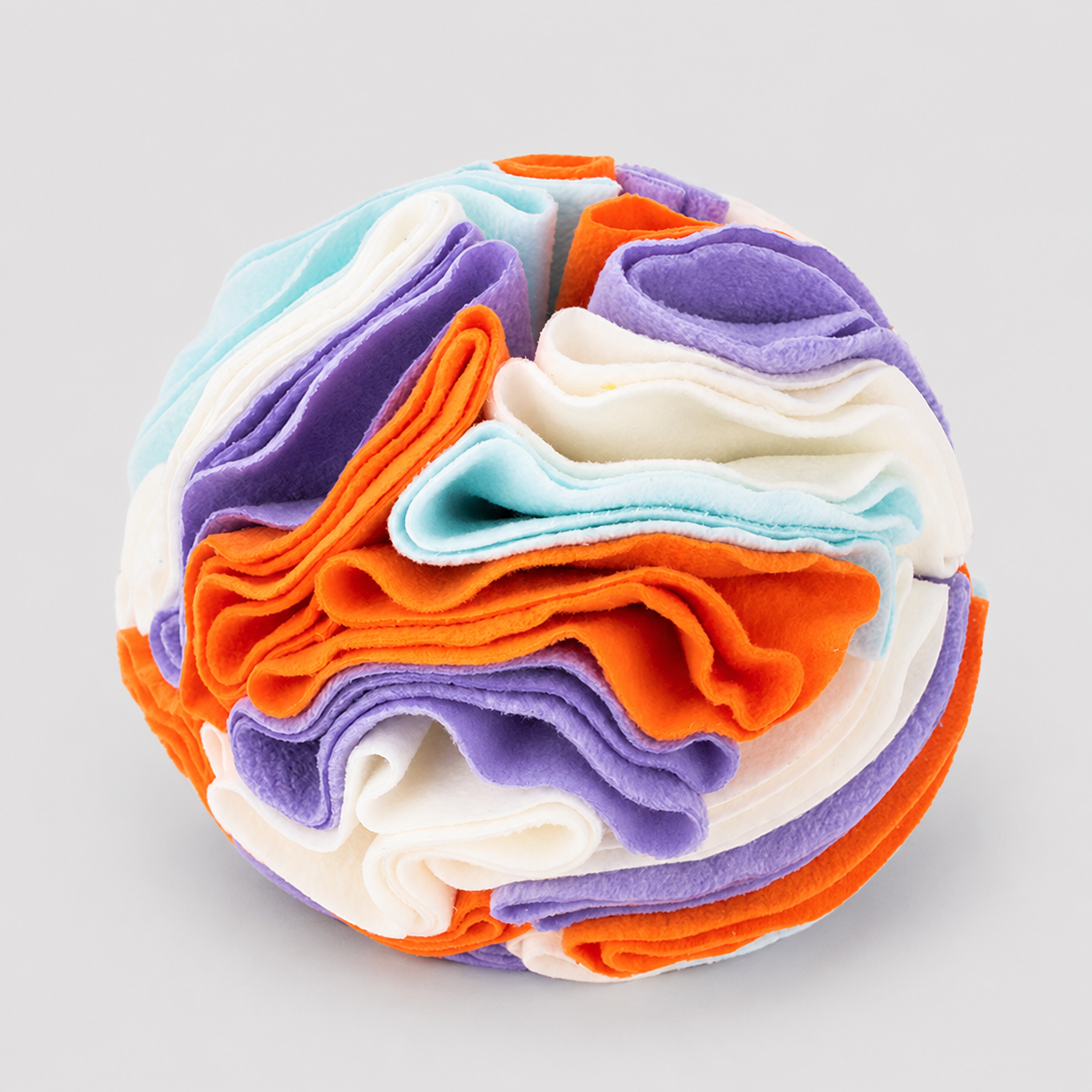 Colorful stack of folded fabric on a light grey background
