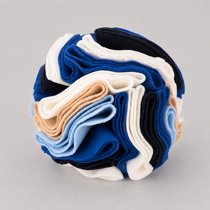 Stack of folded blue, white, and beige felt on a grey background