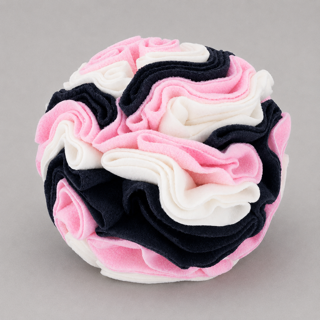 Stack of pink, white and black felt on a grey background