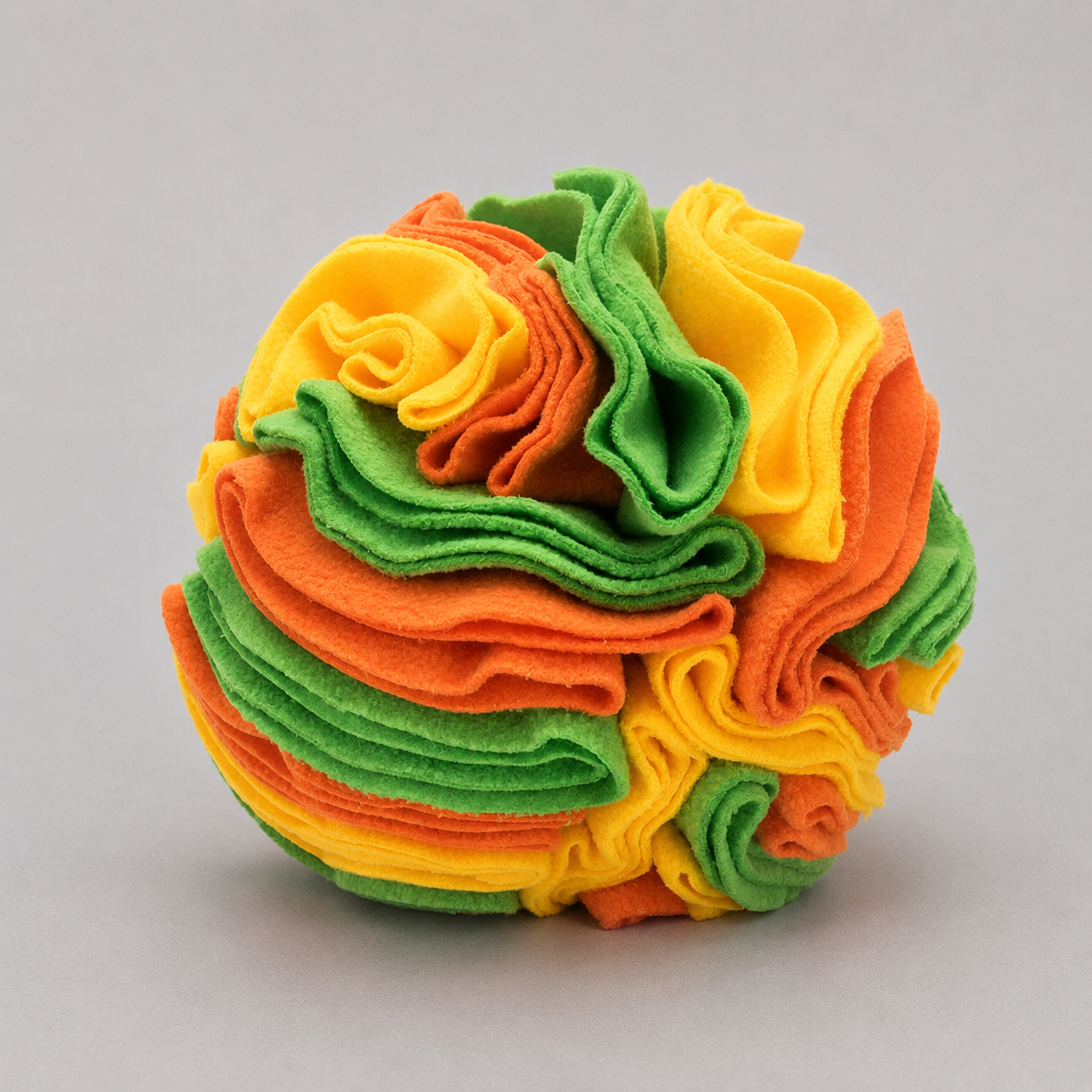Colorful ball made of layered fabric on a grey background