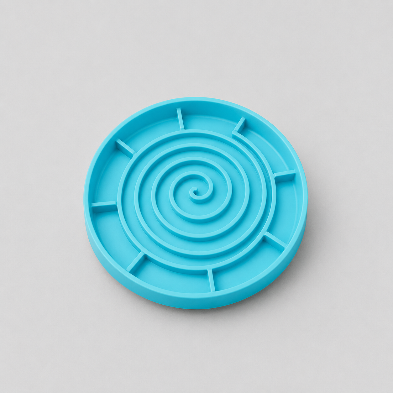 Cyan coloured silicone slow feeder dog bowl on a light grey background