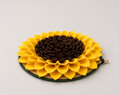Sunflower-shaped dog snuffle mat enrichment toy with yellow petals and brown center on a light gray background